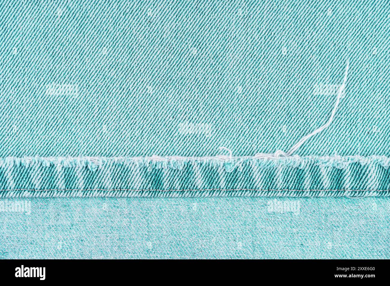 Turquoise denim jeans pantalon Shabby bord sur fond de tissu jean, gros plan, macro. Jean déchiré cousu, détruit déchiré. Fond d'écran, toile de fond, design de Banque D'Images