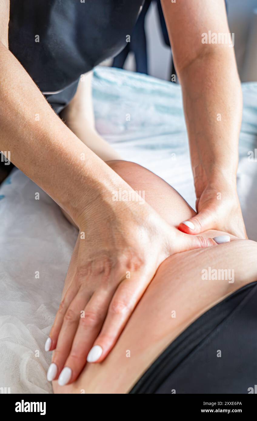 Le masseur fait un massage sur l'abdomen, la taille et les hanches dans le spa. Traitement en surpoids, sculpture corporelle. Le concept de cosmétologie et de massage. Banque D'Images