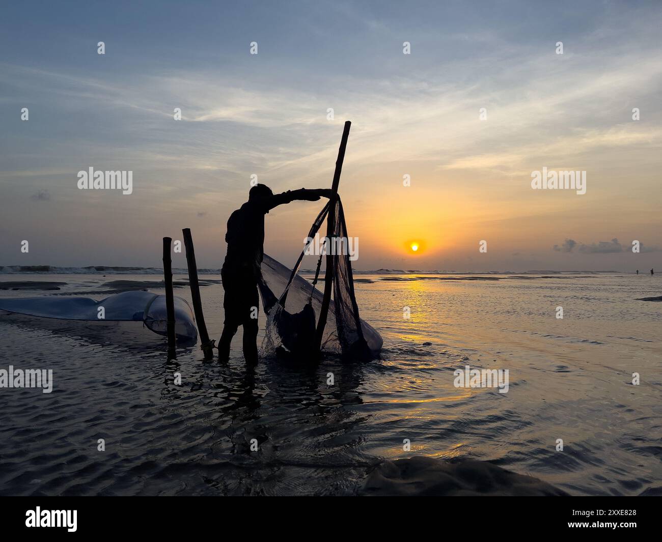 Industrie de la pêche au Bangladesh. Les pêcheurs jettent des filets dans le bazar de cox pendant le coucher du soleil. Contexte économique du Bangladesh. Pêcheur bangladais au coucher du soleil Banque D'Images