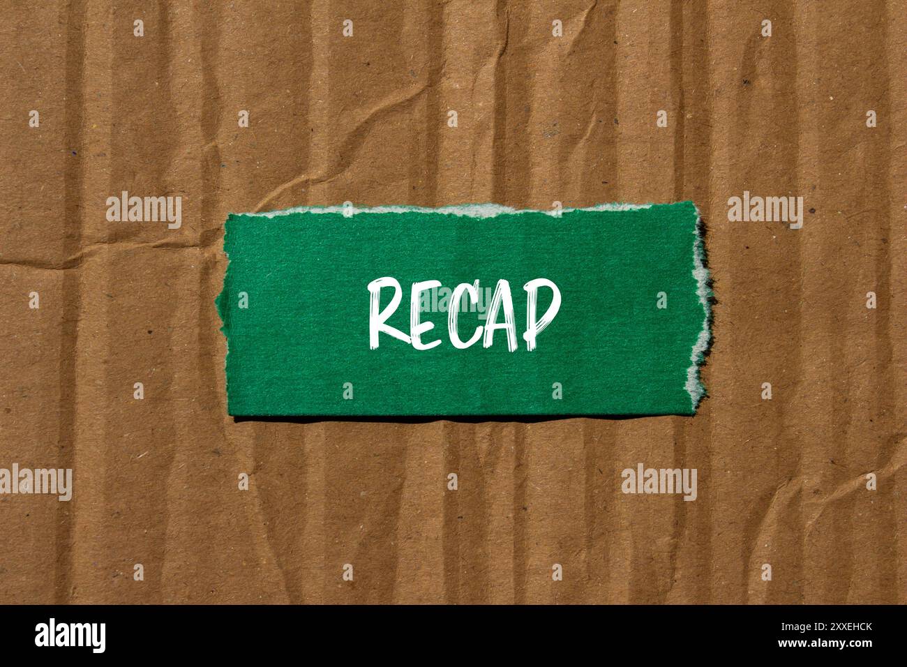 Récapitulez le mot écrit sur un morceau de papier vert déchiré avec un fond de carton. Symbole de mot récapitulatif conceptuel. Copier l'espace. Banque D'Images