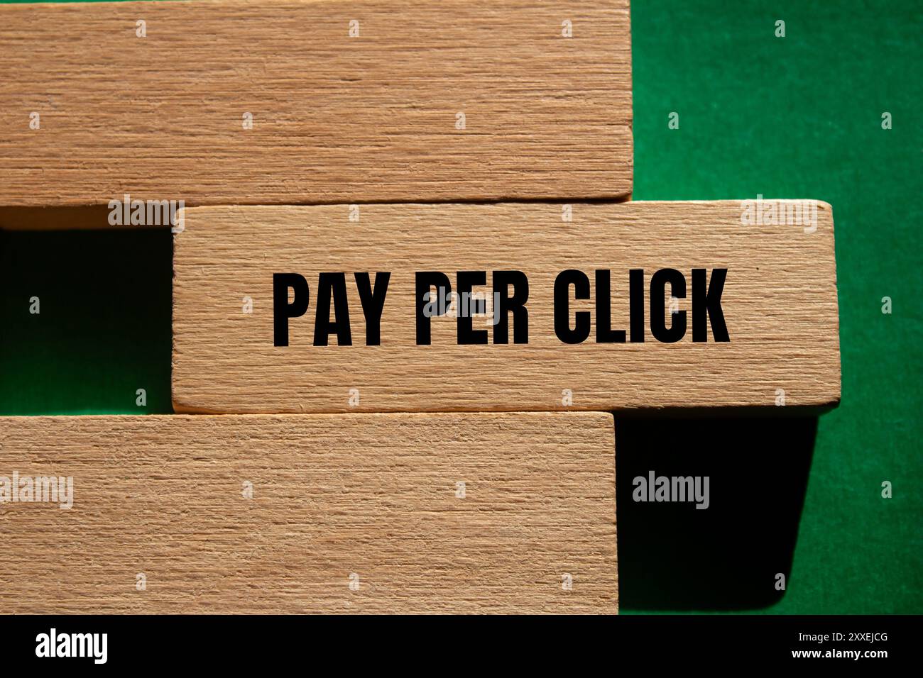 Payer par message de clic écrit sur bloc de bois avec fond vert. Symbole conceptuel de paiement par clic. Copier l'espace. Banque D'Images
