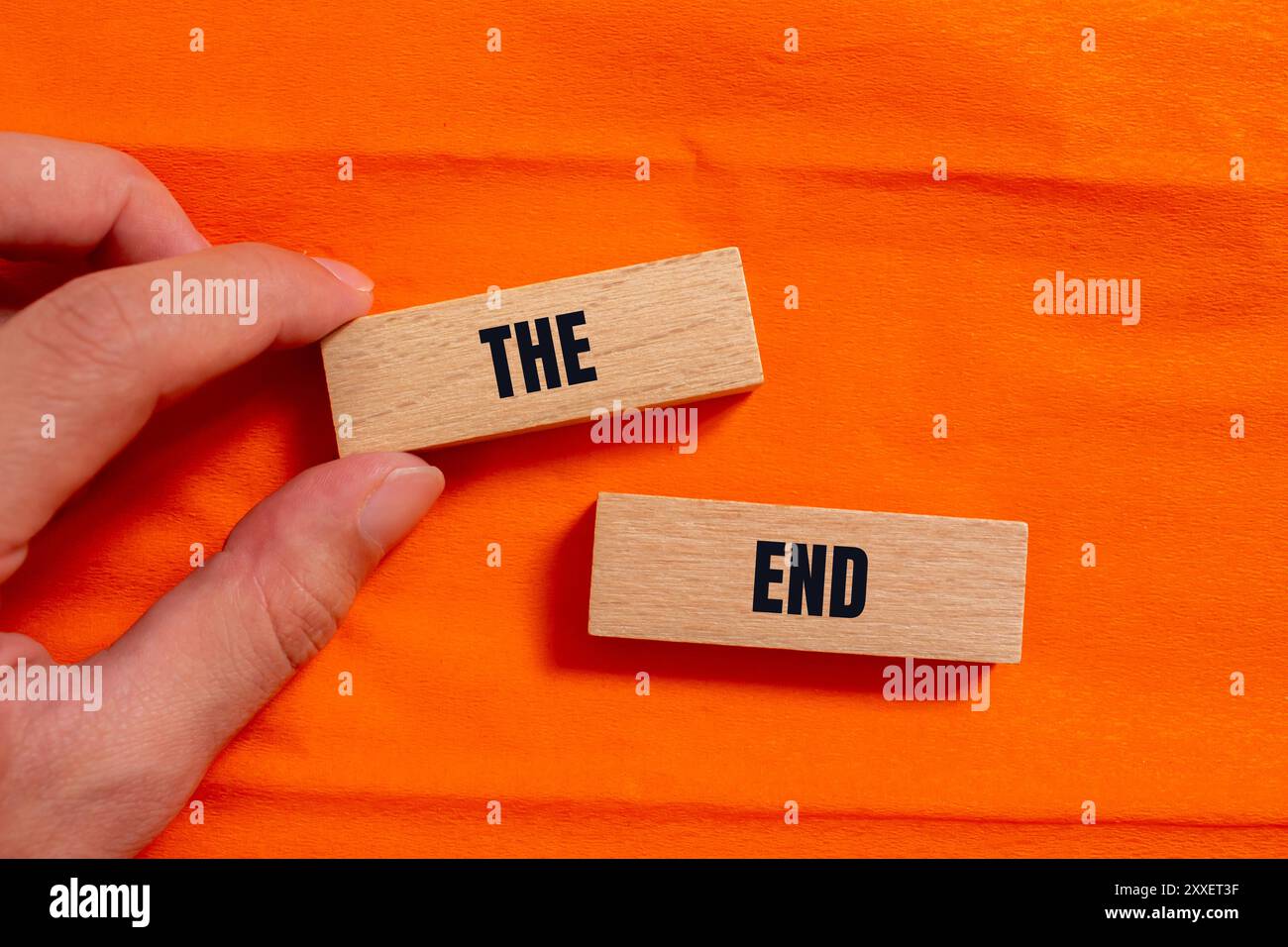 Le message de fin écrit sur des blocs de bois avec fond orange. Conceptuel le symbole de fin. Copier l'espace. Banque D'Images