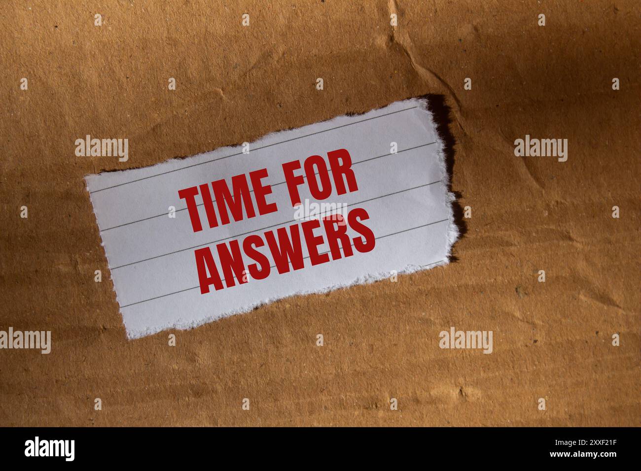 Message temps pour réponses écrit sur un morceau de papier blanc déchiré déchiré avec fond de carton. Symbole temps conceptuel pour les réponses. Copier l'espace. Banque D'Images