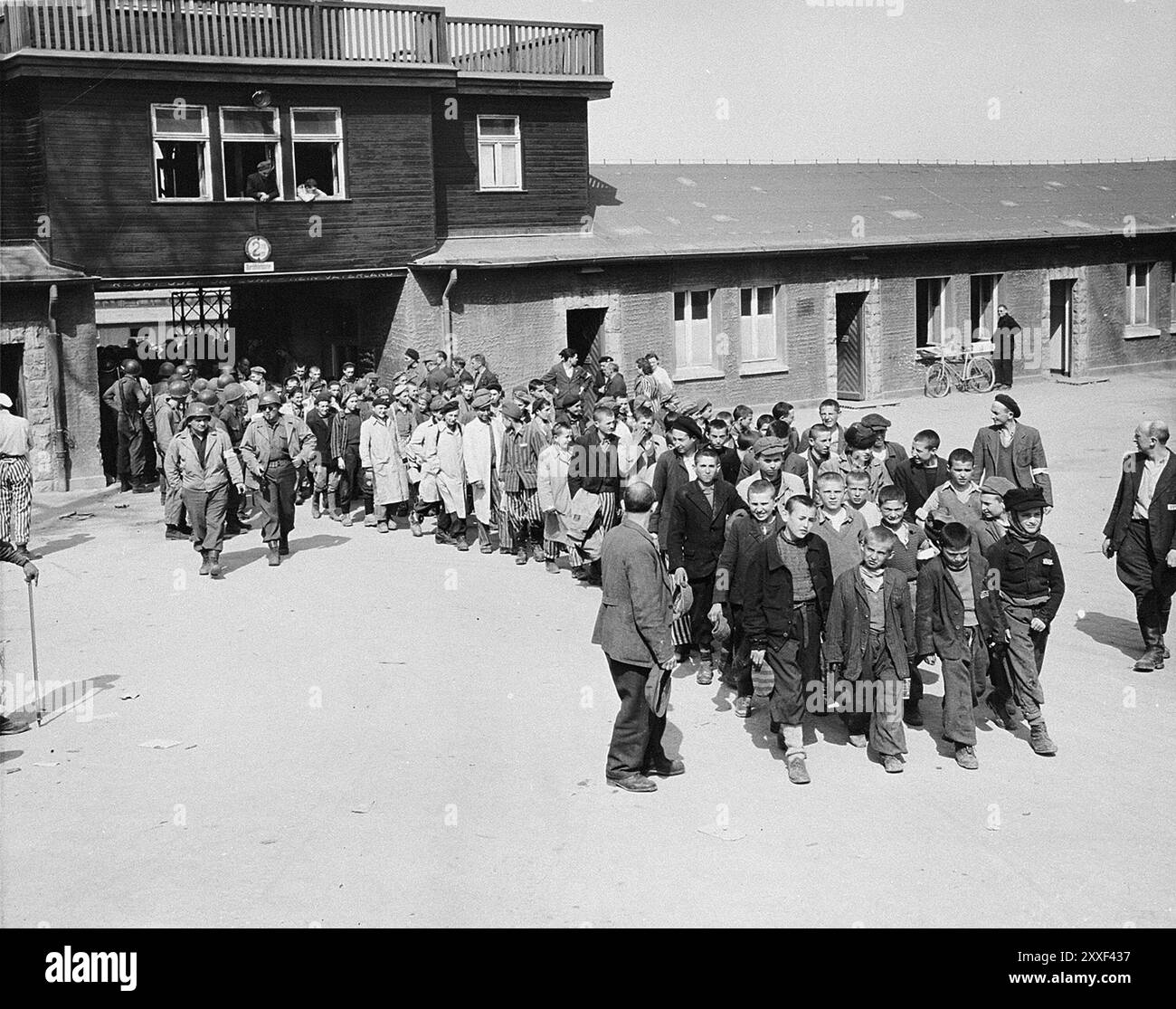 Un grand groupe d'enfants survivants du camp de concentration de Buchenwald part, escortés par des soldats américains. Buchenwald et ses 139 sous-camps étaient des camps de travaux forcés et non des camps de la mort et il n'y avait pas de chambres à gaz. Cependant, les mauvaises conditions, les abus et les exécutions ont entraîné la mort de 56500 personnes dans ce pays. Il a été libéré par l'armée américaine le 11 avril 1945. Banque D'Images