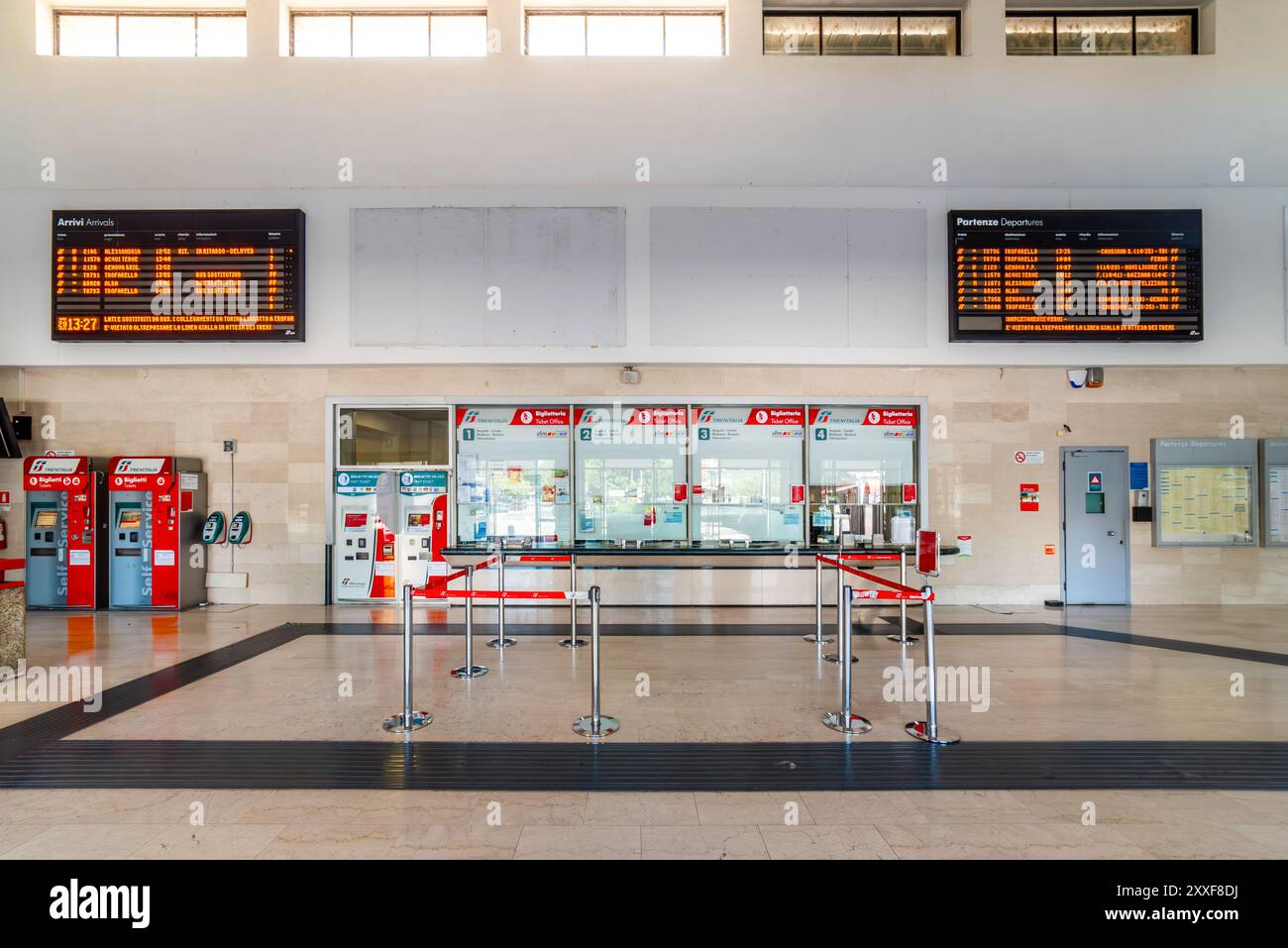 Asti, Italie - 20 août 2024 : les guichets de la gare ferroviaire de Trenitalia avec comptoir de vente de billets et distributeurs automatiques et de grandes enseignes LED pour tra Banque D'Images