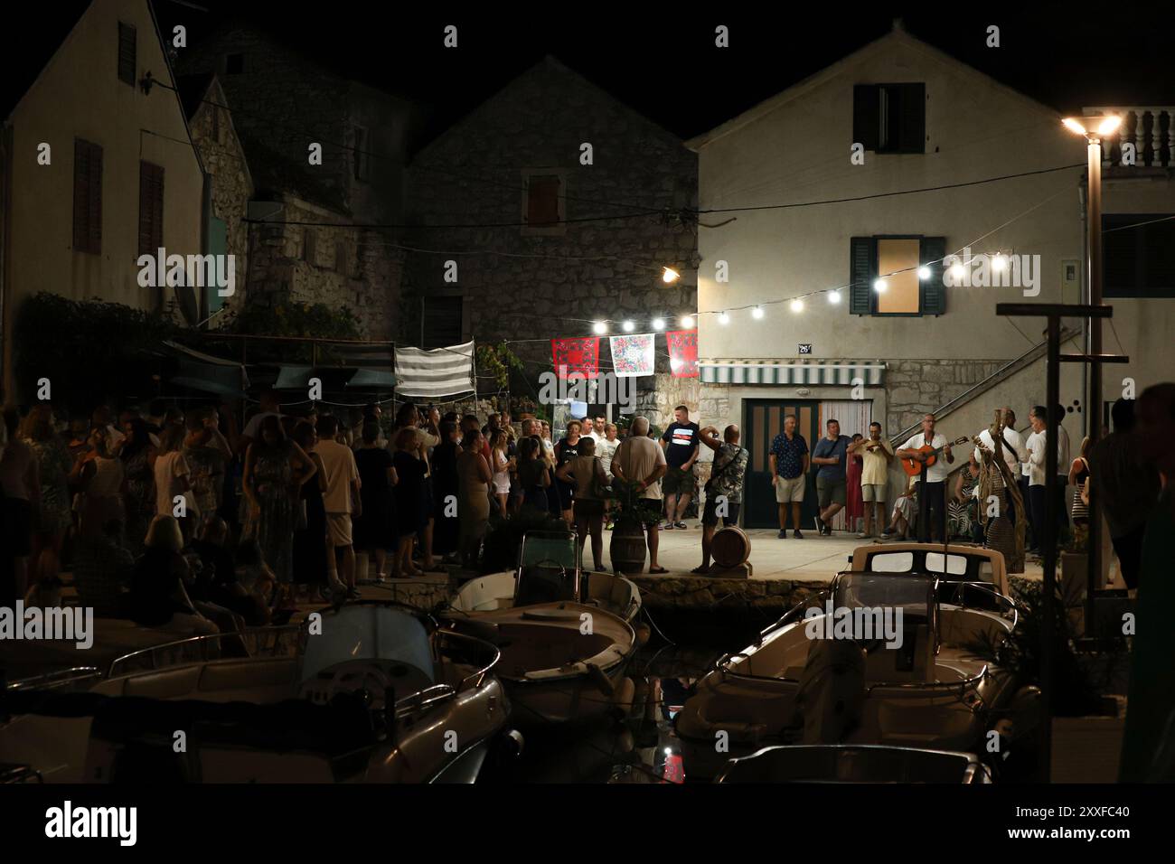 Murter, Dalmatie, Croatie - 10 août 2024 : musique live dans les rues historiques de Murter. Foule de gens dans la ville de nuit Banque D'Images