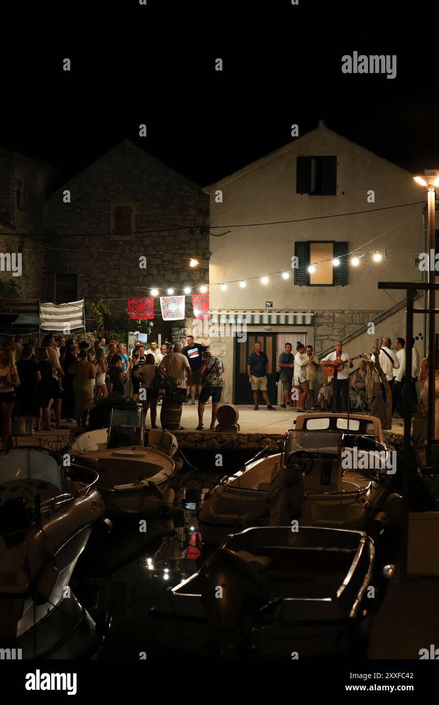 Murter, Dalmatie, Croatie - 10 août 2024 : musique live dans les rues historiques de Murter. Foule de gens dans la ville de nuit Banque D'Images