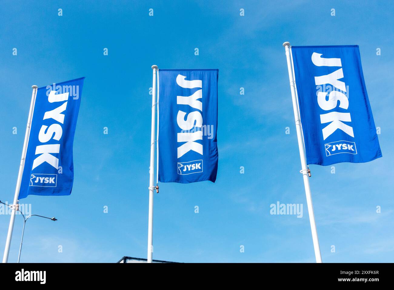 Signez JYSK logo drapeaux contre le ciel bleu Banque D'Images