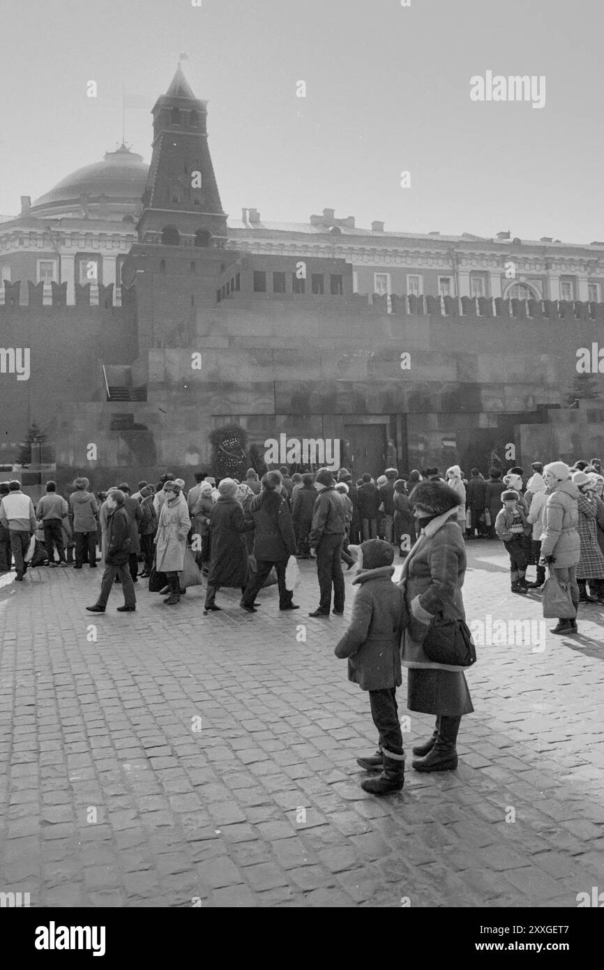 1986 : une foule se rassemble sur la place Rouge devant le Kremlin et le Mausolée de Lénine, où deux gardes d'honneur surveillent. Banque D'Images