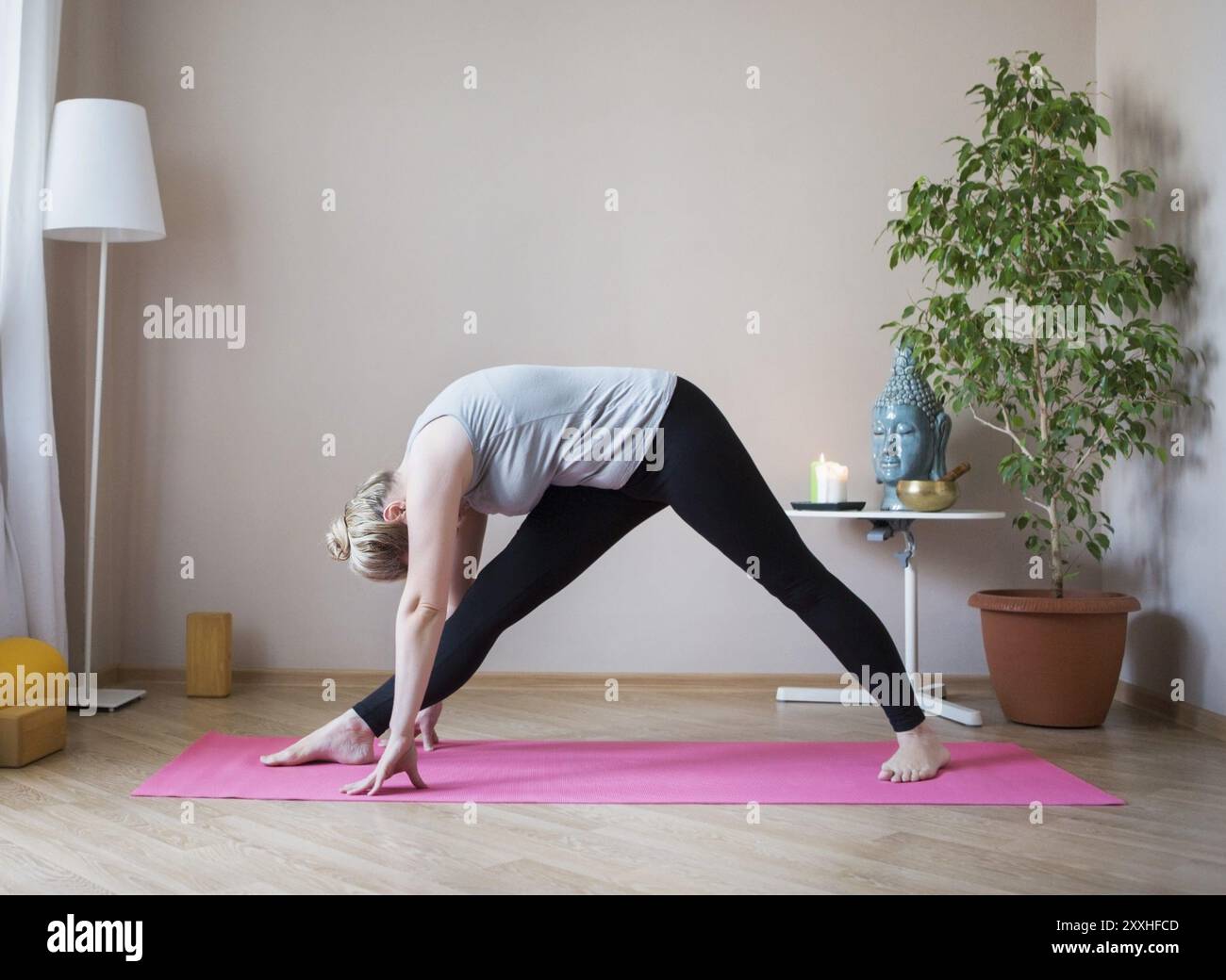 D'âge moyen ou mature woman doing yoga indoors Banque D'Images