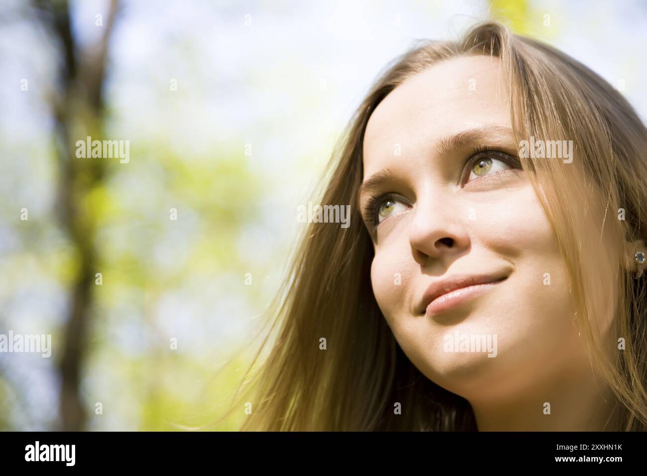 Jeune femme souriant sous la lumière du soleil Banque D'Images