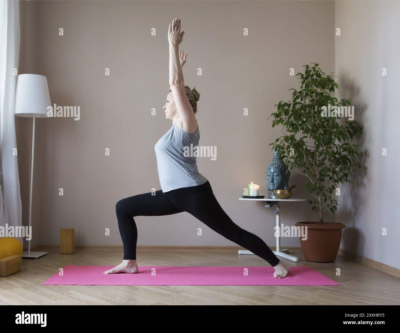 D'âge moyen ou mature woman doing yoga indoors Banque D'Images