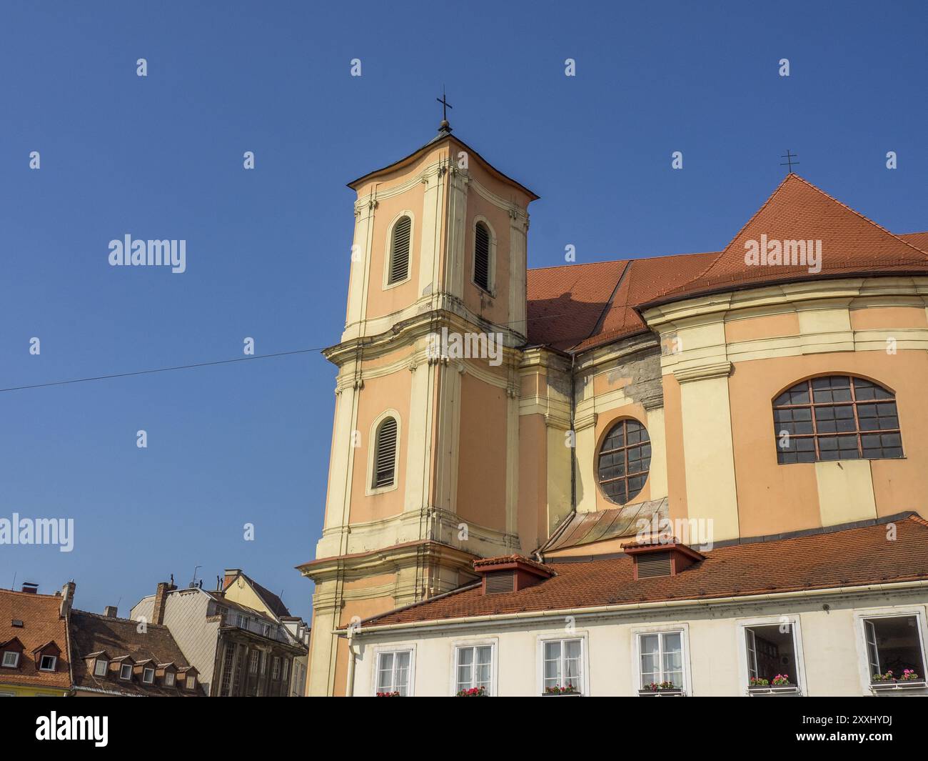 Église baroque avec un toit rouge et des tours dans un environnement urbain, Bratislava, Slovaquie, Europe Banque D'Images