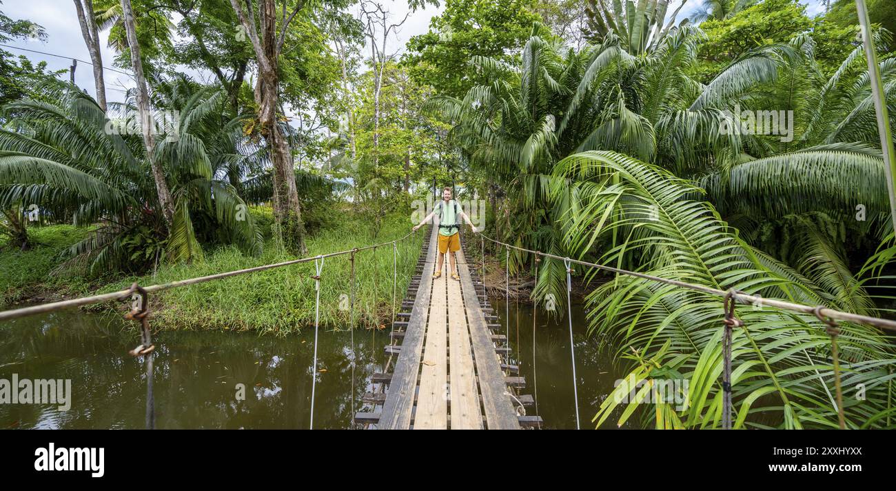 Homme debout sur un pont suspendu, péninsule d'Osa, province de Punterenas, Costa Rica, Amérique centrale Banque D'Images