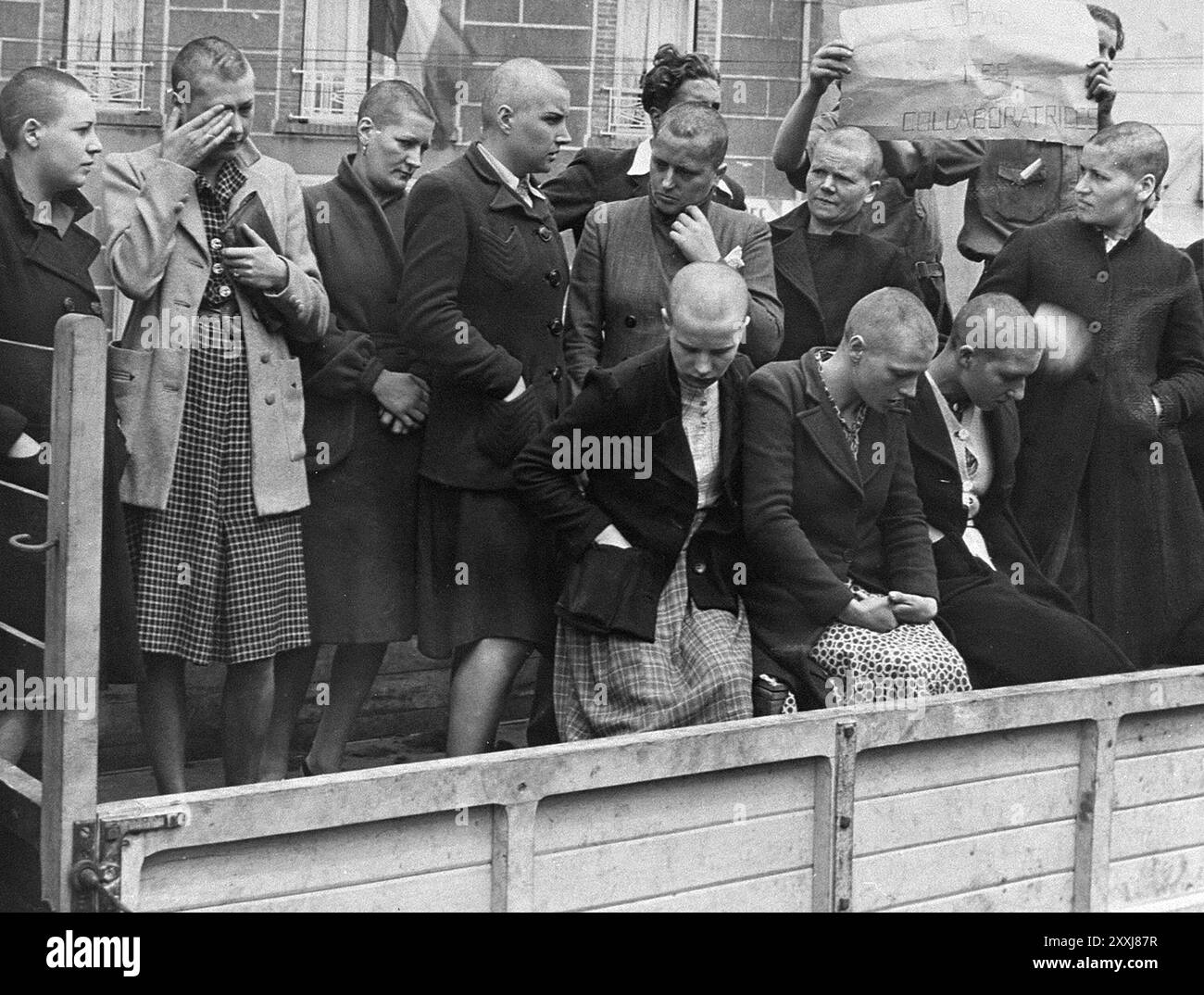 Des femmes pensaient avoir collaboré avec les Allemands punis à Cherbourg. Les membres de la résistance rasent les cheveux de la femme avant de les faire défiler dans les rues. La photo est datée du 14 juillet 1944 Banque D'Images