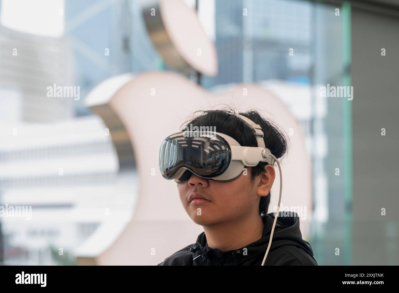 Hong Kong, Chine. 25 août 2024. Un client utilise l'Apple Vision Pro, le nouveau casque de réalité mixte d'Apple, dans le magasin de la multinationale américaine de technologie à Hong Kong. Le Vision Pro combine la réalité augmentée (RA) et la réalité virtuelle (VR) pour fournir une expérience « informatique spatiale », permettant aux utilisateurs d'interagir avec les environnements numériques en utilisant des gestes des yeux et des mains. Crédit : SOPA images Limited/Alamy Live News Banque D'Images