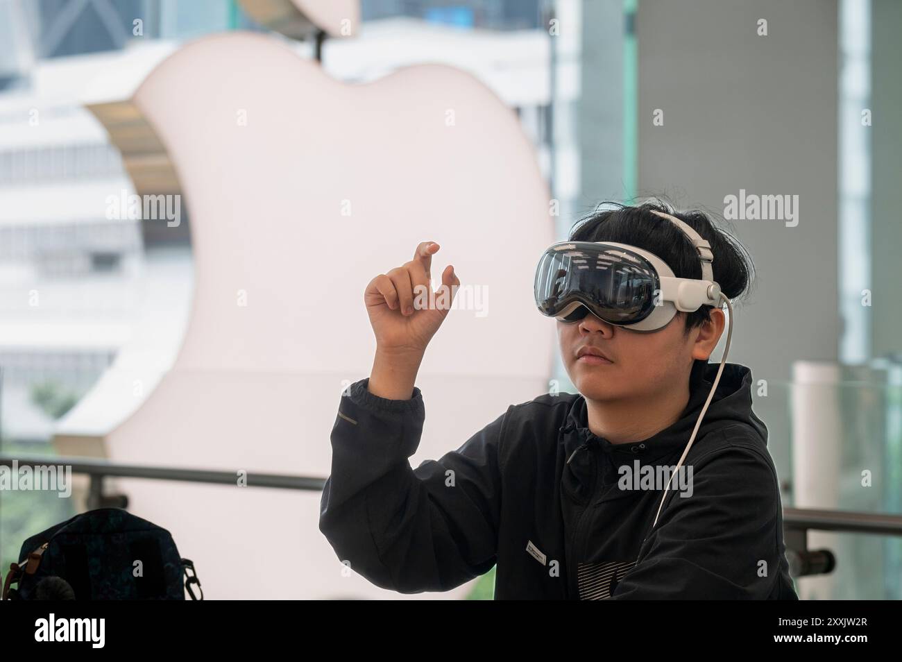 Hong Kong, Chine. 25 août 2024. Un client utilise l'Apple Vision Pro, le nouveau casque de réalité mixte d'Apple, dans le magasin de la multinationale américaine de technologie à Hong Kong. Le Vision Pro combine la réalité augmentée (RA) et la réalité virtuelle (VR) pour fournir une expérience « informatique spatiale », permettant aux utilisateurs d'interagir avec les environnements numériques en utilisant des gestes des yeux et des mains. (Photo de Miguel Candela/SOPA images/SIPA USA) crédit : SIPA USA/Alamy Live News Banque D'Images