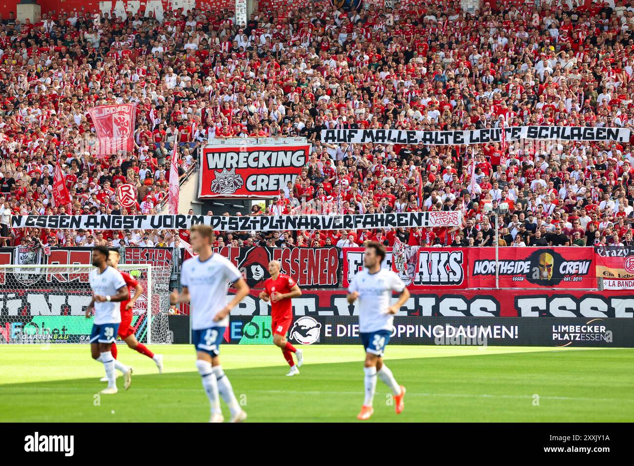 RWE fans zeigen Spruchband 'Auf malle alte Leute schlagen, in Essen Angst vor m Disziplinarverfahren'. Grund : Mutmaßlich waren vier Polizisten aus Essen in einer Prügelei mit einem Taxifahrer auf Mallorca verwickelt. Rot-Weiss Essen (RWE, Rot Weiß Essen) gegen DSC Arminia Bielefeld AM 24. Août 2024 im Stadion an der Hafenstraße (Nordrhein-Westfalen/Deutschland/GER). Fußball, 3. Spieltag der 3. Liga saison 2024/2025. Stand : 0:0 vor 18,507 Zuschauer. Banque D'Images