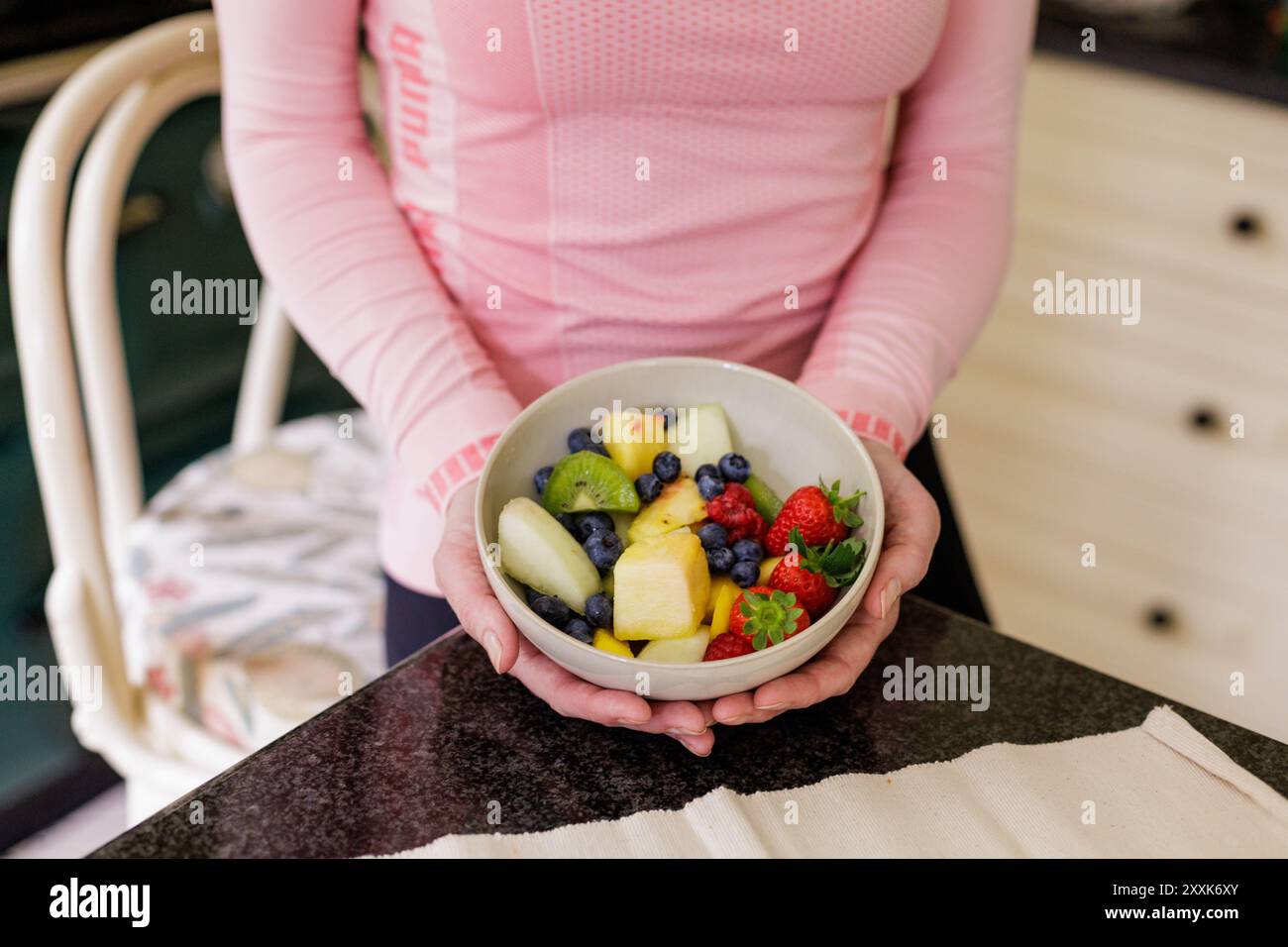 Gros plan d'un bol de salade de fruits nutritive et saine contenant des baies d'été, du melon et du kiwi. Banque D'Images