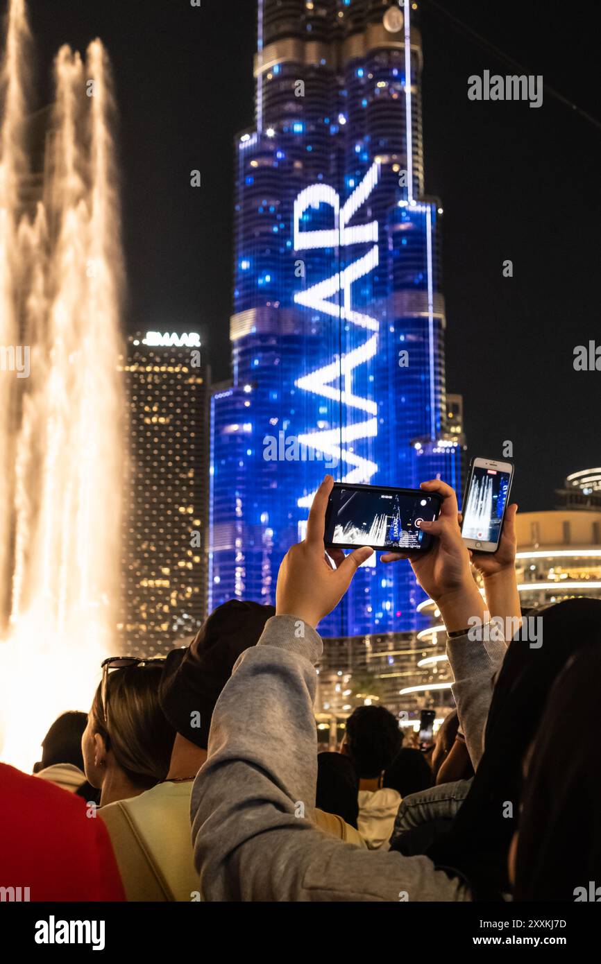 Touristes photographiant le spectacle de lumière au Burj Kalifa eau beaucoup de gens enregistrent le spectacle laser sur les téléphones intelligents au Burj Khalifa. Voyageurs et touri Banque D'Images