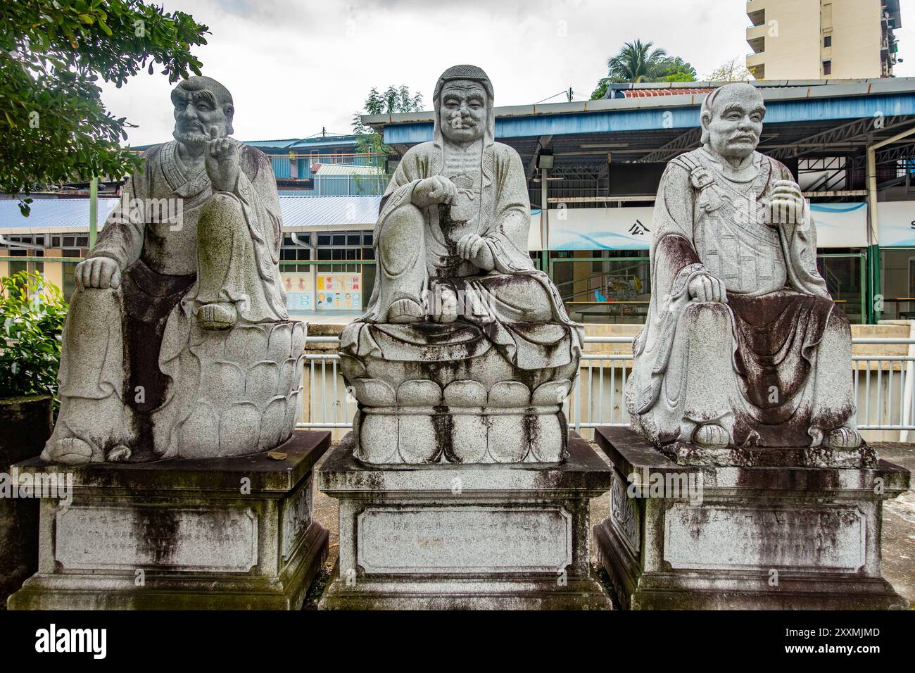 Des personnages bouddhistes étaient assis sur des piédestaux dans le parking principal des visiteurs du temple Kek Lok si à Penang, en Malaisie. Banque D'Images