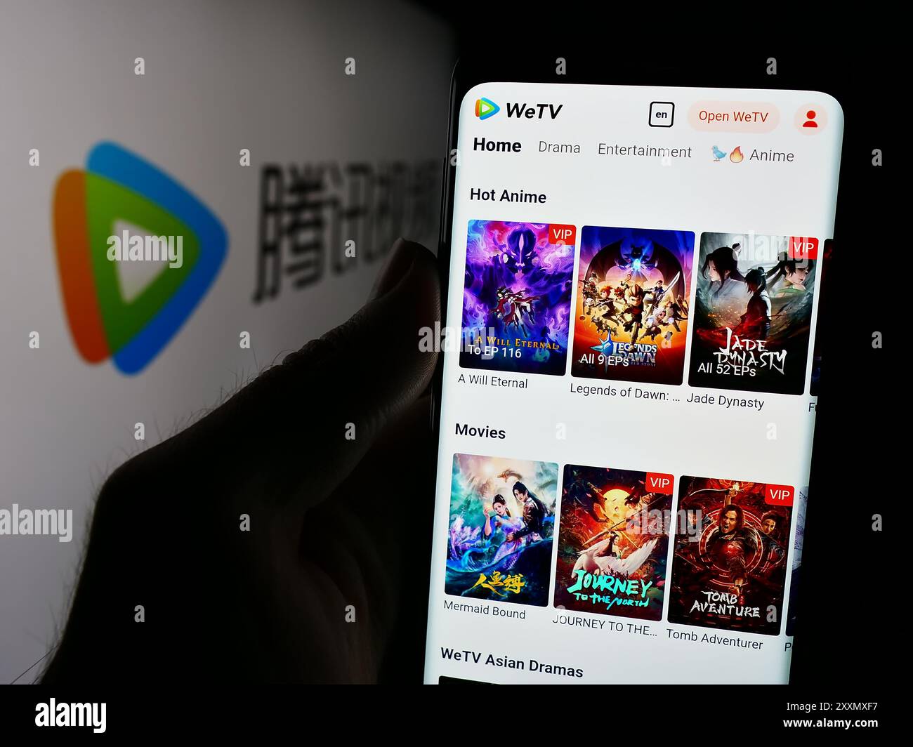 Personne tenant le téléphone portable avec la page Web du service chinois de streaming vidéo Tencent Video (WeTV) devant le logo. Concentrez-vous sur le centre de l'écran du téléphone. Banque D'Images