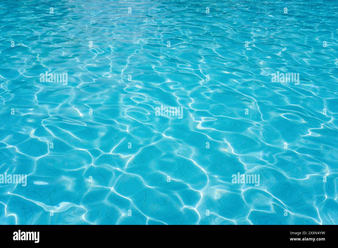 Eau de piscine bleue claire chatoyante dans la lumière du soleil. Banque D'Images