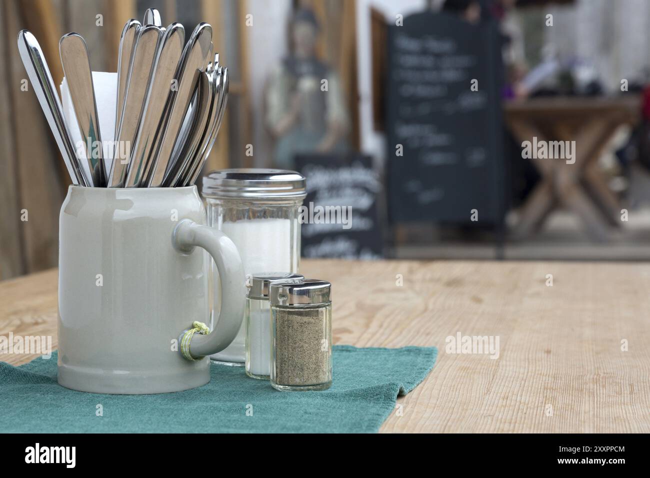 Des couverts dans une tasse de bière sur une table en bois Banque D'Images