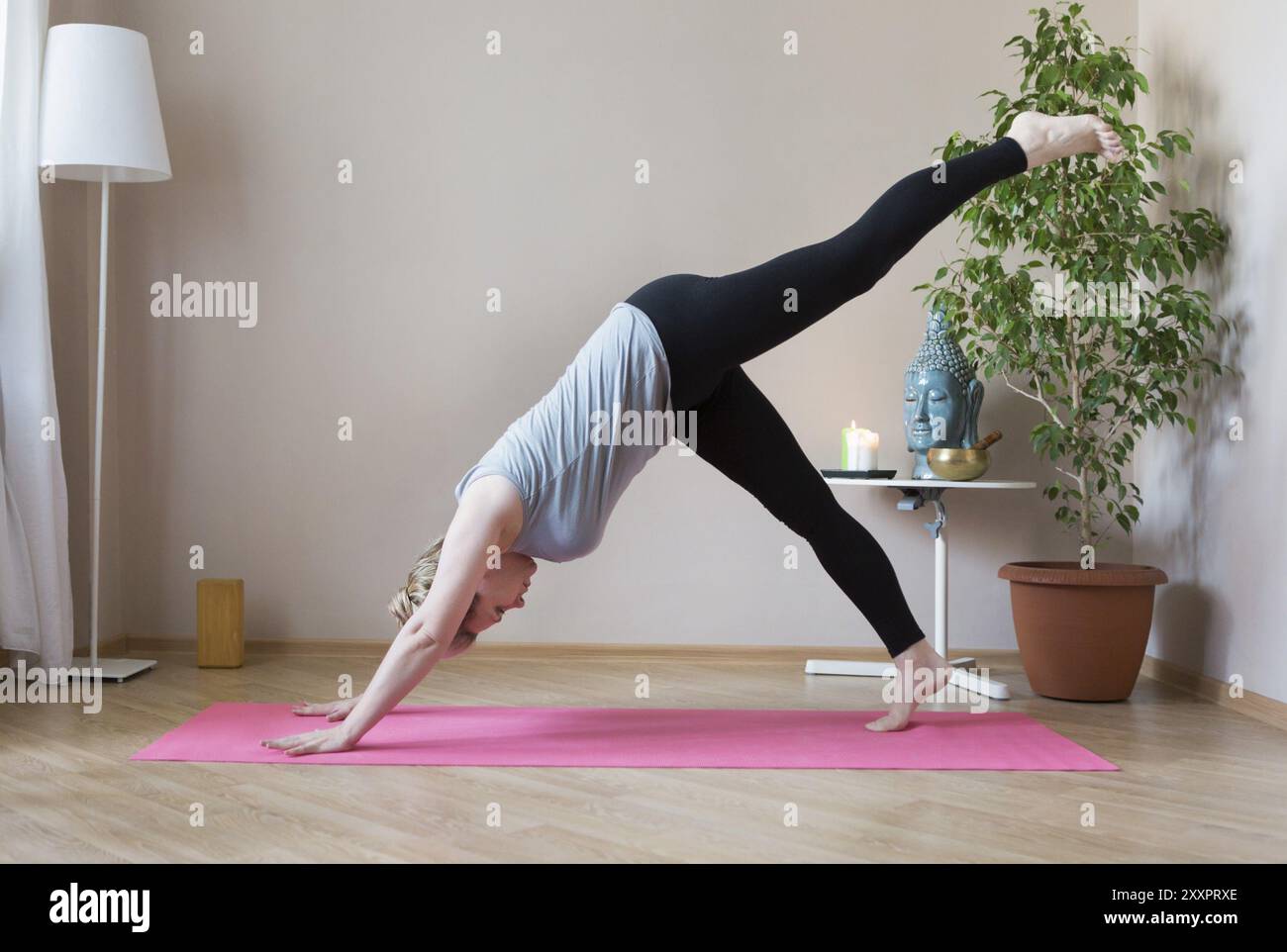 D'âge moyen ou mature woman doing yoga indoors Banque D'Images