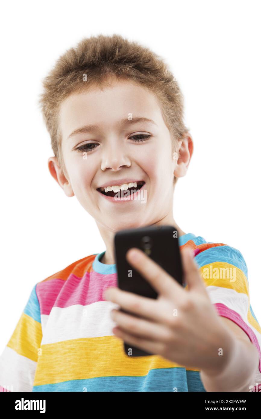 Petit garçon enfant souriant main tenant le téléphone portable ou smartphone faisant selfie photo portrait blanc isolé Banque D'Images