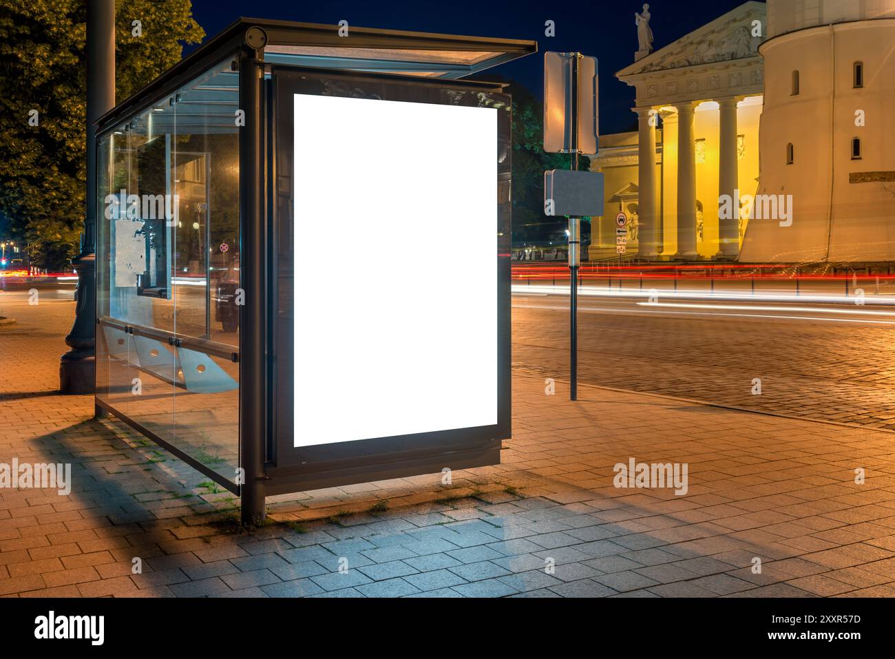 Maquette d'un panneau publicitaire d'arrêt de bus sur Une rue de la ville la nuit. Boîte à lumière affiche avec des sentiers de lumière de voiture en arrière-plan Banque D'Images