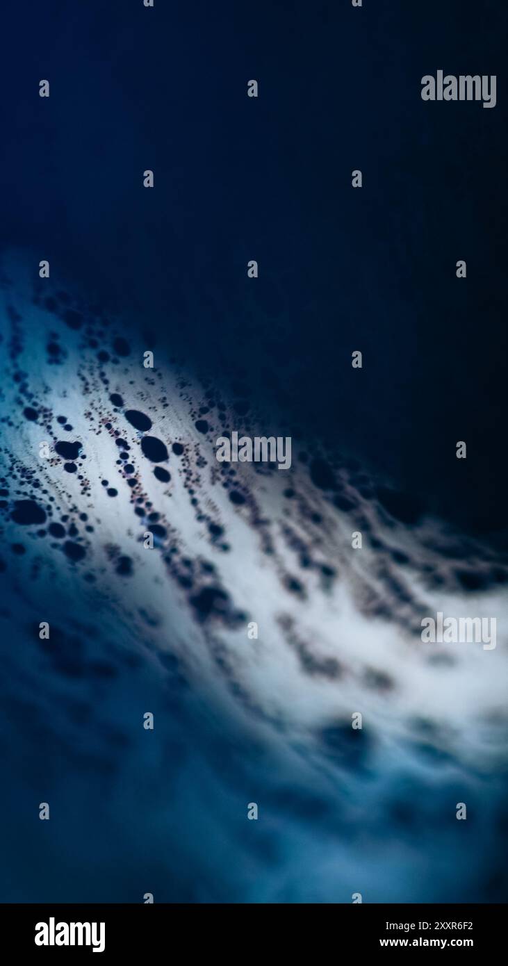 Peinture à bulles. Liquide acide. Flou défocalisé d'émulsion d'huile de couleur bleue fuite flaque d'eau lisse sur fond d'art abstrait d'éclat de lumière noire sombre. Banque D'Images