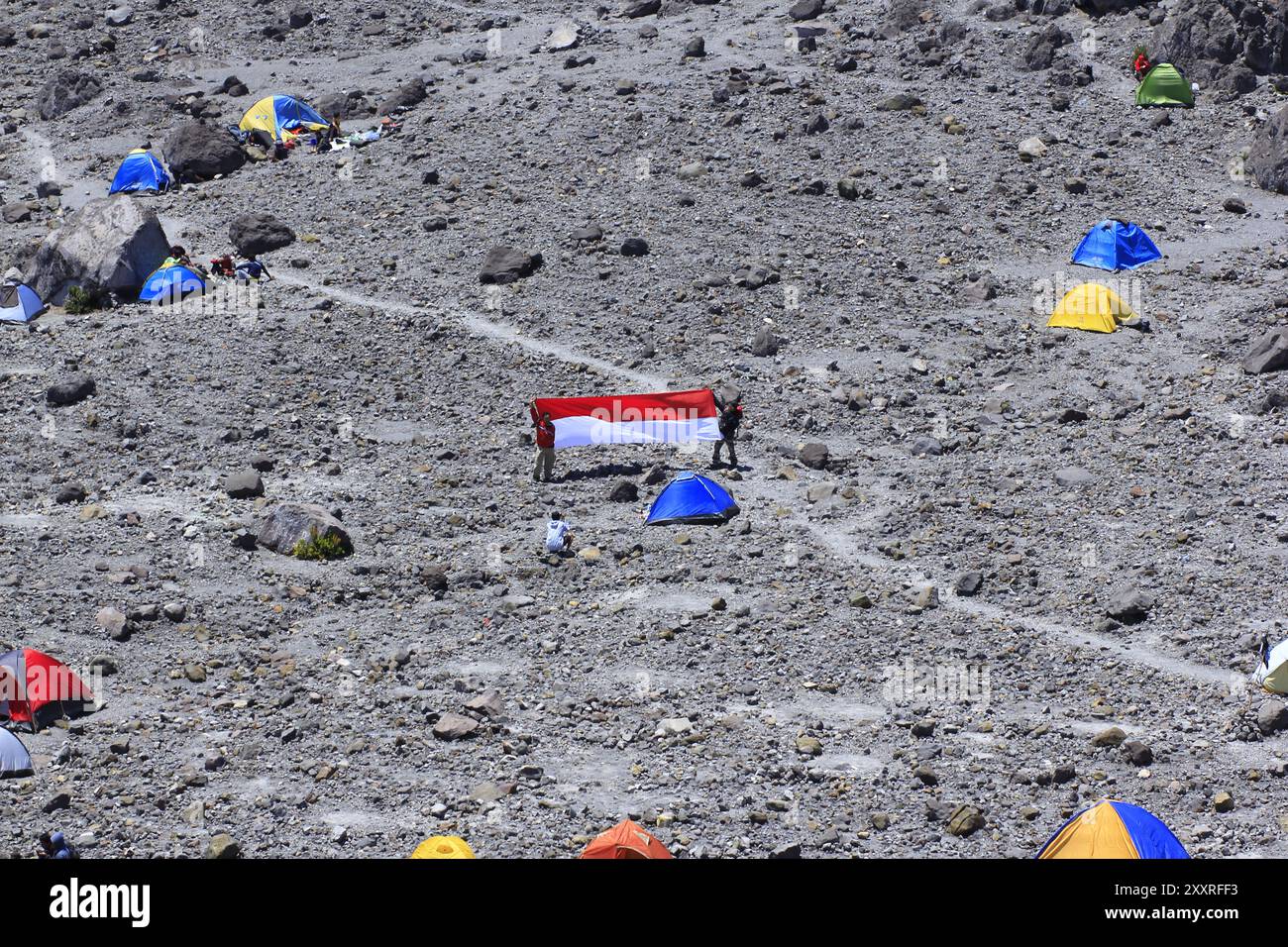 Les grimpeurs étalent des tissus rouges et blancs symbolisant le drapeau national indonésien dans la zone de champ de sable de ​​Pasar Bubrah, avant le sommet du Merapi. Banque D'Images