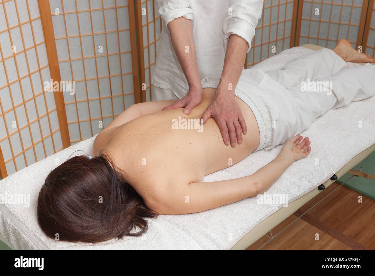 thérapeute effectue un massage shiatsu sur le dos d'une femme sur une table de massage Banque D'Images