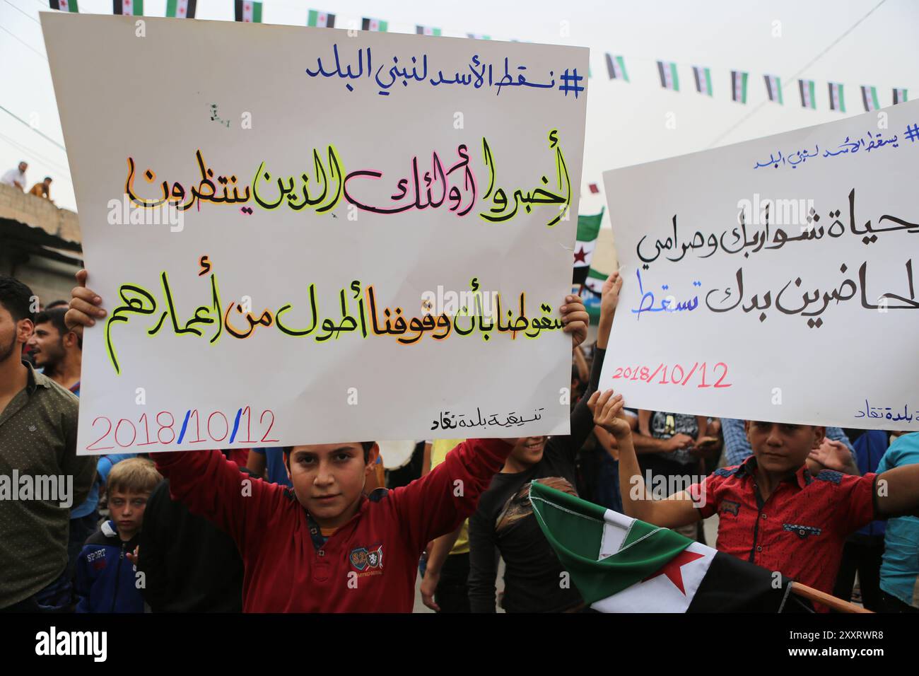 Une manifestation anti-Assad a lieu dans la ville de Taqad, dans la campagne occidentale d'Alep, où une foule s'est rassemblée de Taqad et des villages voisins d'Anjara, Tarmanin, Basartuna et Atareb, hissant le drapeau de la Révolution et des bannières pro-révolutionnaires. Les manifestants ont exigé le renversement du président syrien Bachar Al-Assad, défendant les principes de la révolution tels que la liberté et la justice. Ils ont également appelé les forces russes à ne pas pénétrer dans les zones contrôlées par l'opposition et à libérer les détenus de l'opposition. Des signes de solidarité avec les personnes déplacées se sont tenus Banque D'Images