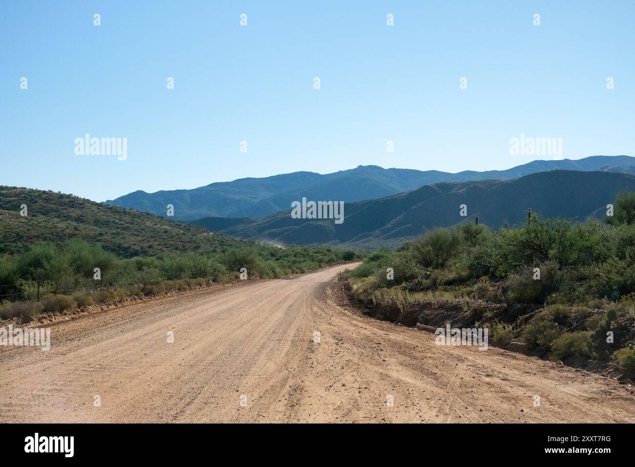 Des chemins de terre s'envolent dans un arrière-plan montagneux Banque D'Images