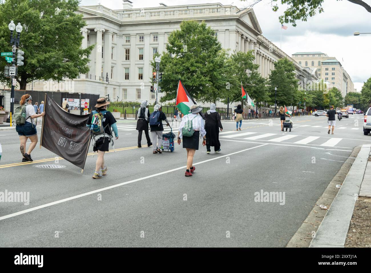 Washington DC, USA - 19/2024 : un groupe de manifestants défilent dans la rue avec des panneaux et des banderoles. Une femme en chemise bleue marche au milieu Banque D'Images