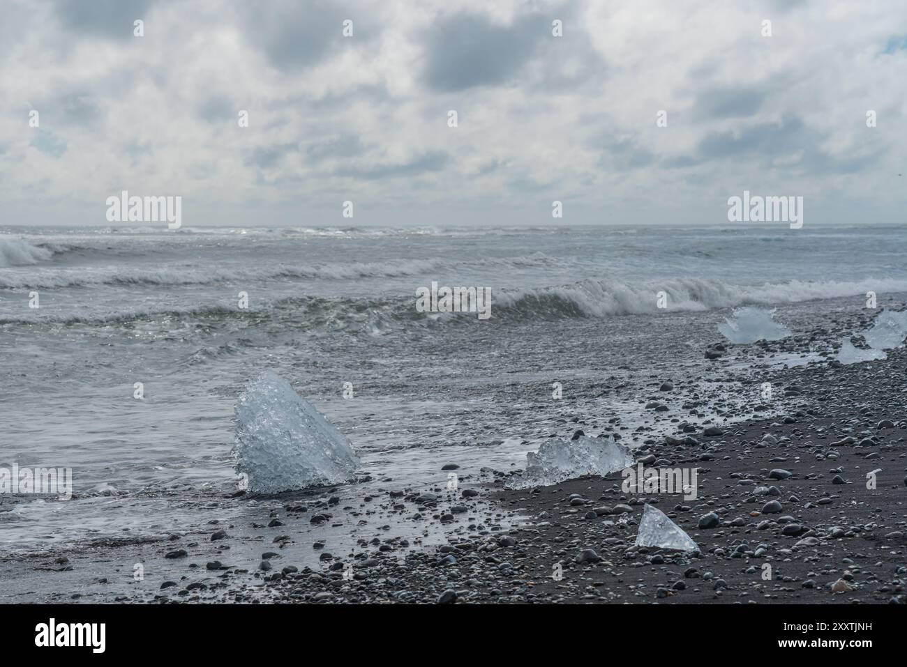 Morceaux de glace et icebergs cassés sur une plage volcanique de sable noir à Diamond Beach en Islande Banque D'Images