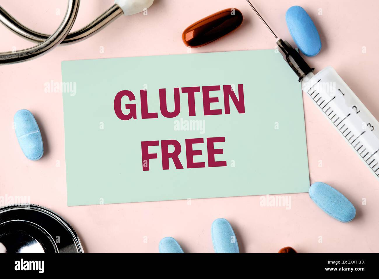Mots SANS GLUTEN écrits sur la carte de visite dans une composition avec un stéthoscope, des pilules et une seringue. Banque D'Images
