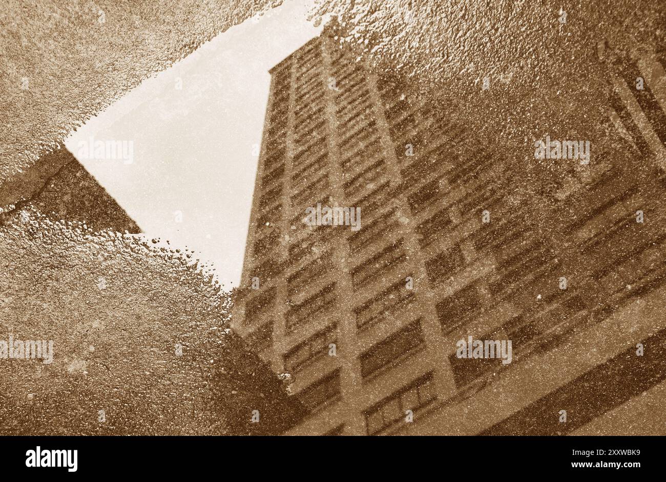Image sépia de hauts bâtiments se reflétant sur la flaque Banque D'Images