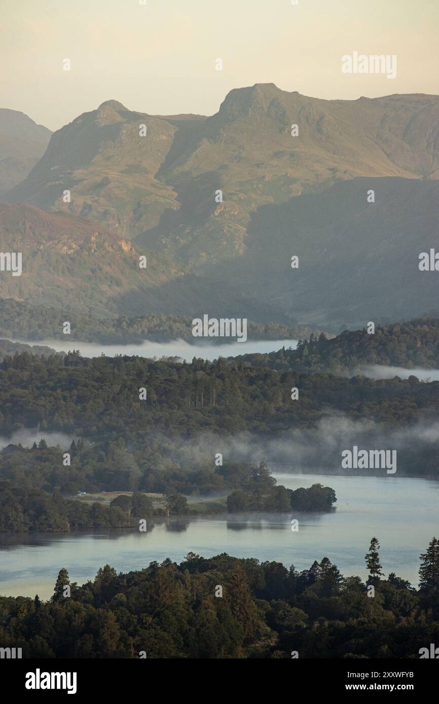 Une belle vue matinale sur Windermere jusqu'aux spectaculaires Langdale Pikes dans le Lake District, prise depuis le point de vue d'Orrest Head après le lever du soleil. Banque D'Images