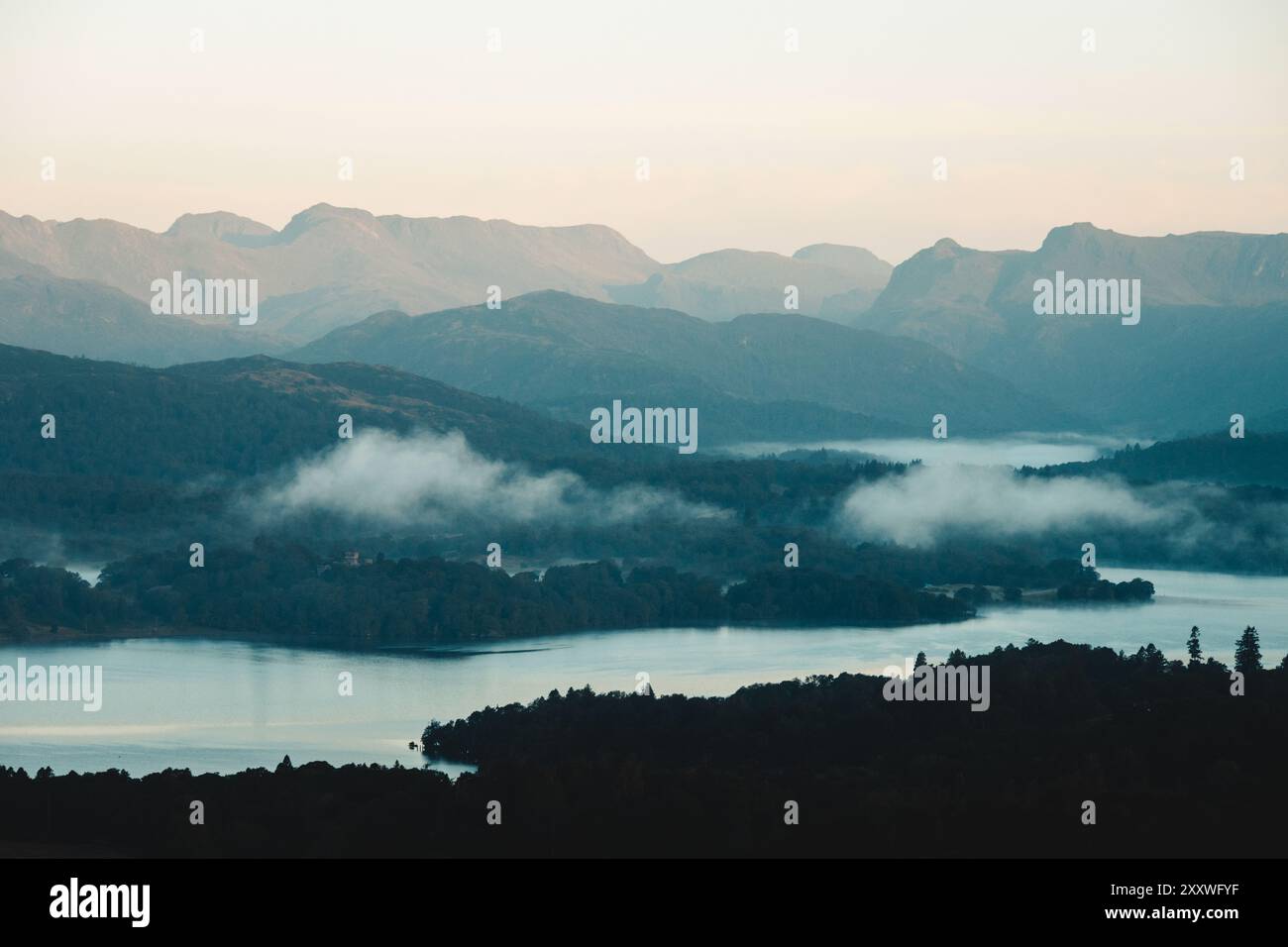 Une belle vue matinale sur Windermere jusqu'aux spectaculaires Langdale Pikes dans le Lake District, prise depuis le point de vue d'Orrest Head après le lever du soleil. Banque D'Images