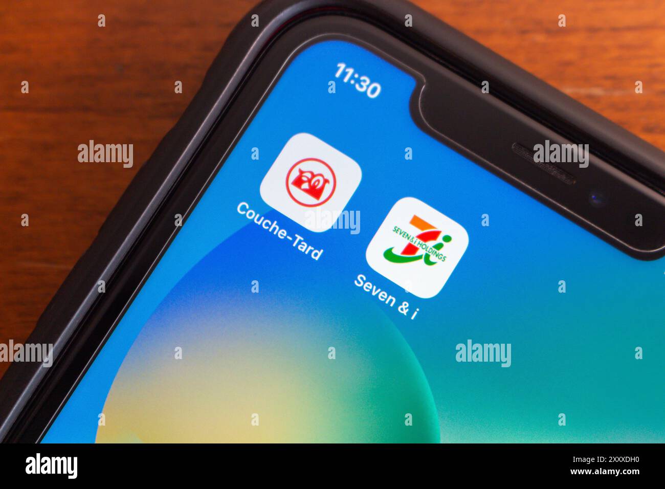 Couche-tard et Seven et I Holdings co icônes vus dans un iPhone. Couche-tard a proposé d'acquérir Seven & i Holdings pour se développer en Asie-Pacifique Banque D'Images