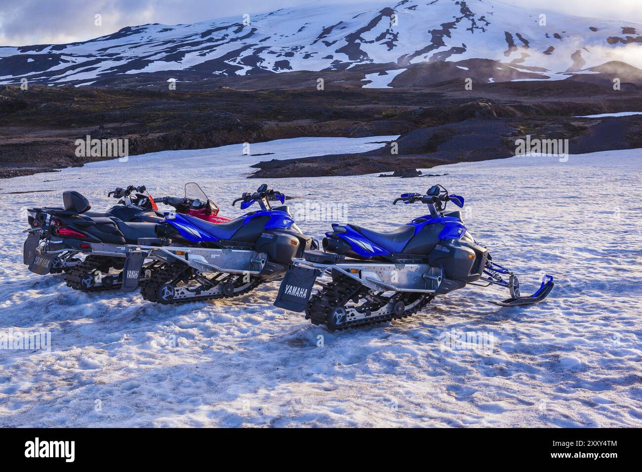 ISLANDE, 04 JUILLET : quatre motoneiges stationnées dans une rangée dans une épaisse neige hivernale en Islande dans un paysage hivernal froid désolant le 04 juillet 2013 à I. Banque D'Images