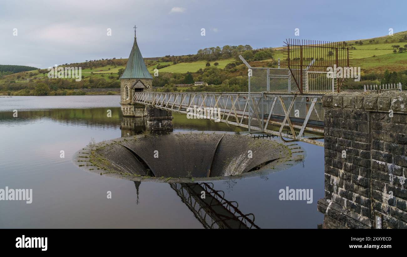 Vue en soirée sur le réservoir de Pontsticill près de Merthyr Tydfil, Mid Glamorgan, pays de Galles, Royaume-Uni, avec le débordement et la tour de valve Banque D'Images