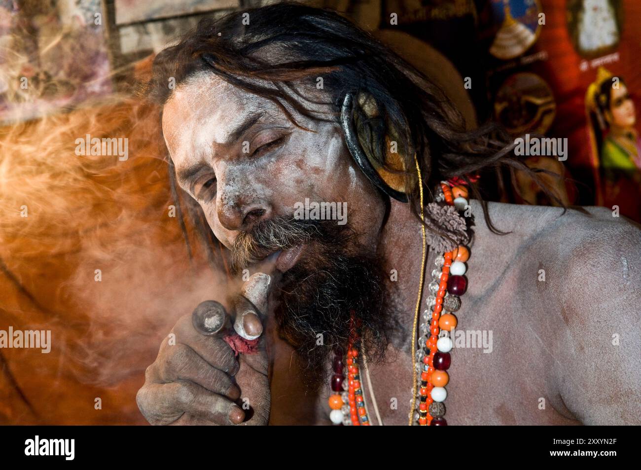 Un Naga Sadhu fumeurs son chillum. Banque D'Images