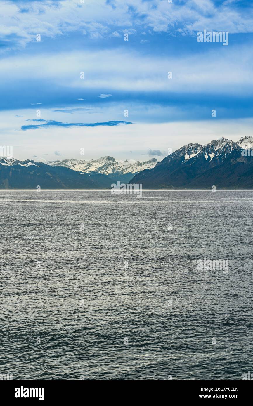 Vue à l'est depuis le terminal ferry Lausanne-Ouchy sur le lac Léman. Au loin se trouvent Montreux et Port Valais. Avec des montagnes enneigées au-dessus. Banque D'Images