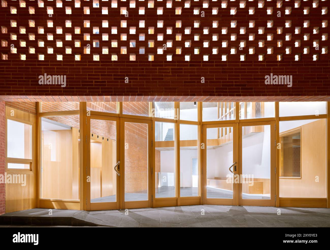 Une entrée contemporaine de l'auditorium présentant un plafond en briques frappant avec la lumière naturelle filtrant à travers, complétée par des portes en bois et un i chaleureux Banque D'Images