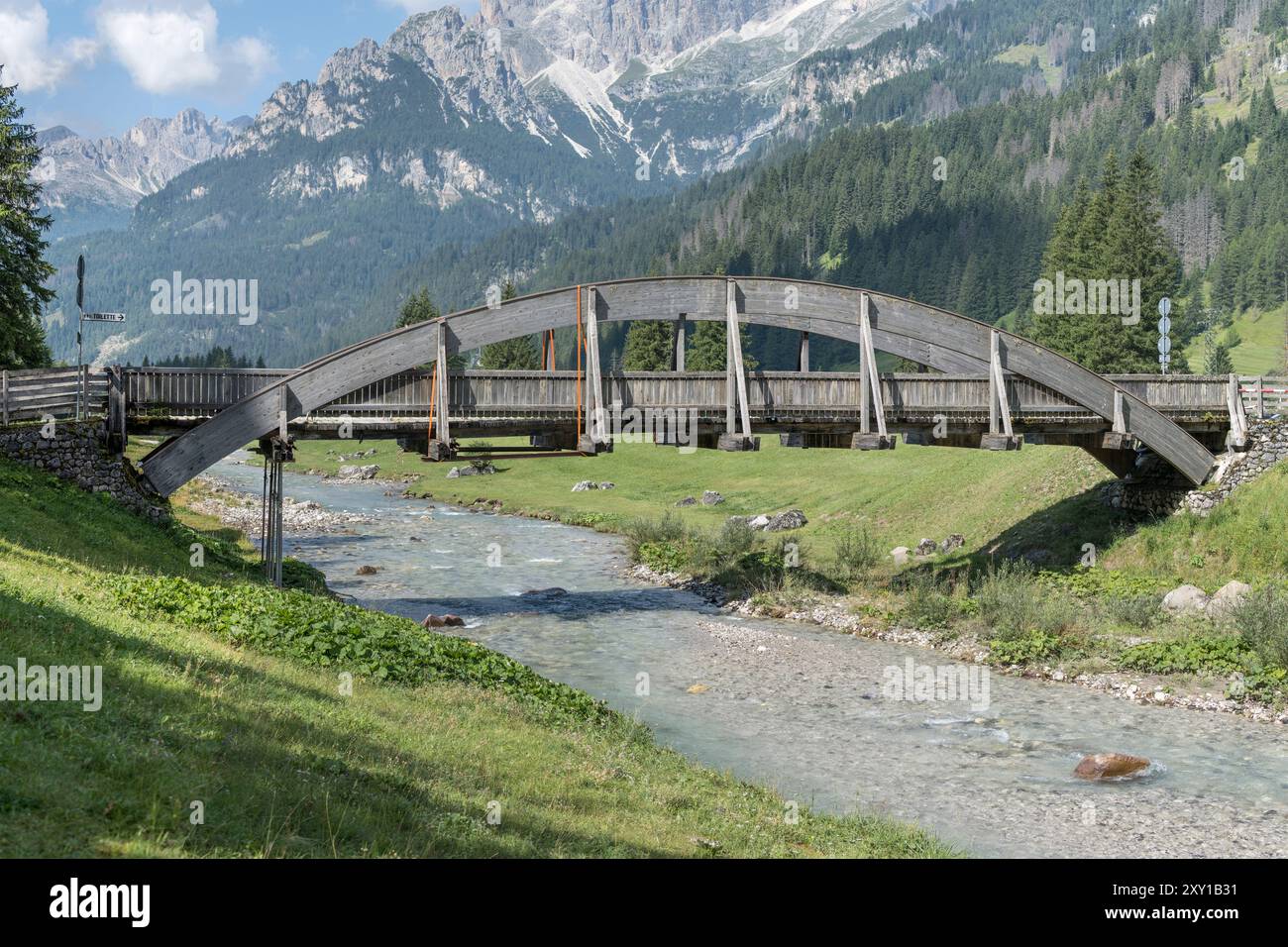 Paysage avec pont en bois sur la rivière Avisio et la chaîne de montagnes Catinaccio en arrière-plan, tourné de l'est dans la lumière d'été à Fontanazzo di Fassa Banque D'Images