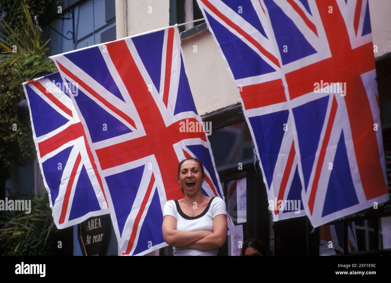 Mariage royal du Prince Edward et Sophie Rhys-Jones au château de Windsor. Des drapeaux de l'Union Jack pendent d'un bâtiment et une femme rit. Berkshire, Angleterre 19 juin 1999 1990s Royaume-Uni HOMER SYKES Banque D'Images